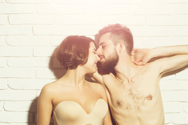 bearded slim man and pretty woman in bra kiss - Фото, изображение
