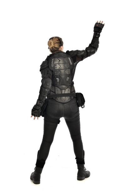 full length portrait of female  soldier wearing black  tactical armour  facing away from the camera, isolated on white studio background. - Zdjęcie, obraz