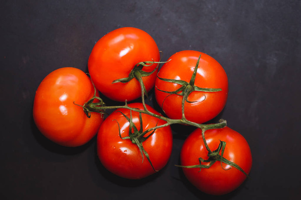 Ripe red tomatoes on black background, top view. - 写真・画像