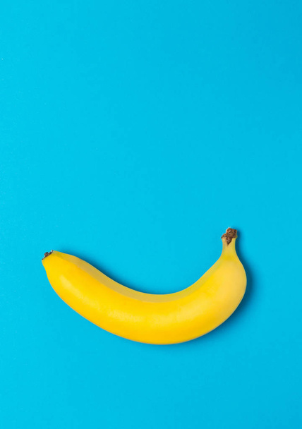 Single fresh, yellow, ripe banana on cyan - Фото, изображение