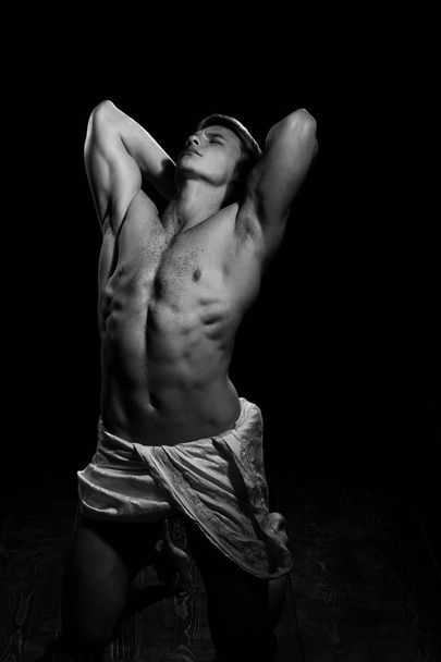Man with muscular wet body in white fascia. - Φωτογραφία, εικόνα