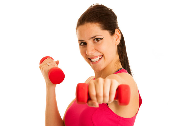 Active young woman wprkout with dumbbells in a fitness gym - 写真・画像