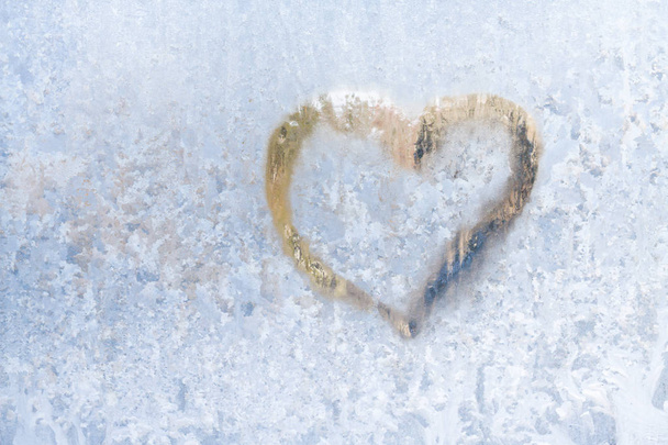 Heart on a frosty winter in the frozen patterns of ice window - Fotografie, Obrázek