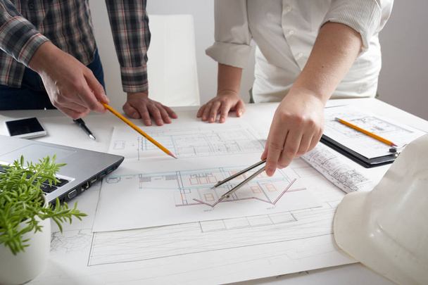 Architects working on blueprint, real estate project. Architect workplace - architectural project, blueprints, ruler, calculator, laptop and divider compass. Construction concept. Engineering tools. - Foto, Imagem