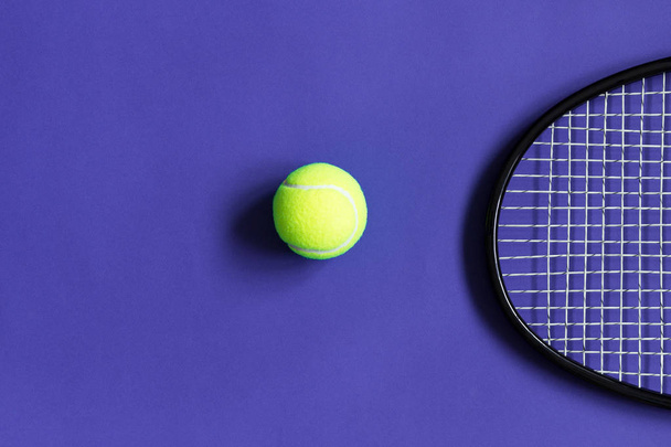 Pelota de tenis y raqueta. Fondo violeta. Concepto deporte. Copiar espacio
 - Foto, imagen