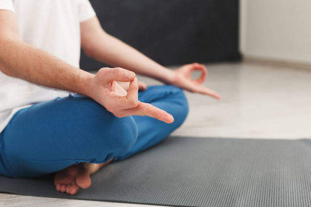 Молодой человек медитирует в спортзале
 - Фото, изображение