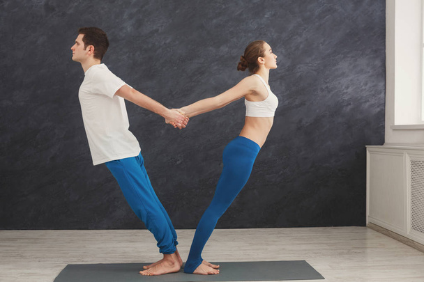 Pareja entrenamiento yoga en equilibrio pose, de pie espalda con espalda
 - Foto, Imagen