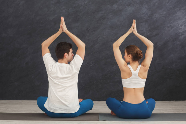 Giovane coppia praticare yoga seduto in padmasana
 - Foto, immagini