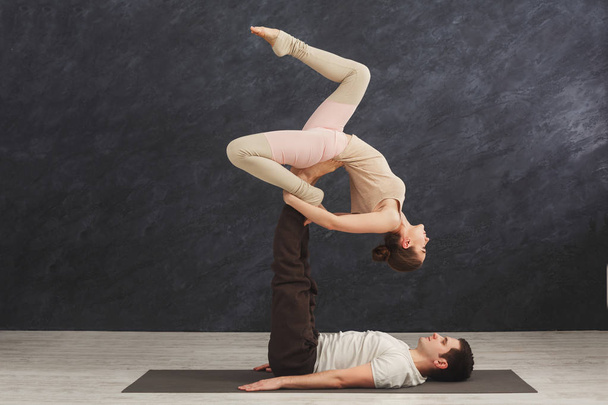 Mladý pár spolu cvičí acroyoga na mat - Fotografie, Obrázek