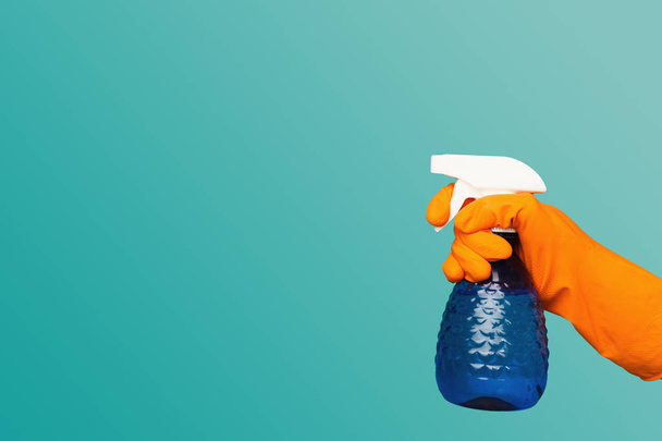 eine Hand im Handschuh hält Spray der Reinigungsflüssigkeit - Foto, Bild