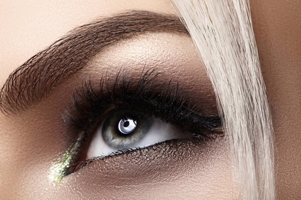Beautiful female eye with extreme long eyelashes, black liner makeup. Perfect make-up, long lashes. Closeup fashion eyes - Photo, Image