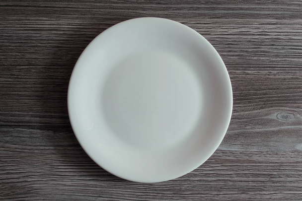 Пустая белая керамическая плита на сером деревянном фоне
 - Фото, изображение