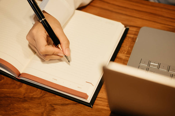 pohled shora. rukou podnikatel držet pero psát na notebooku. počítač - Fotografie, Obrázek