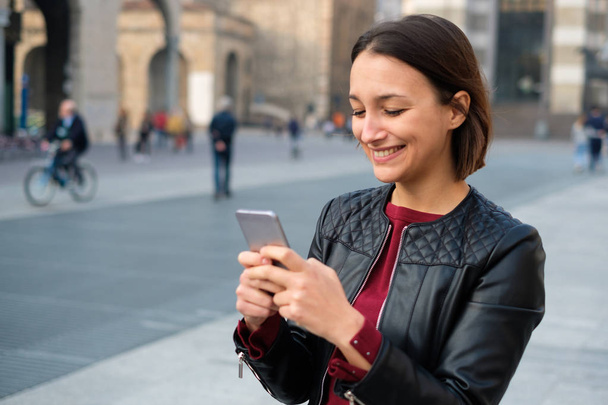 Woman holding smart phone for urban city communication - Photo, Image
