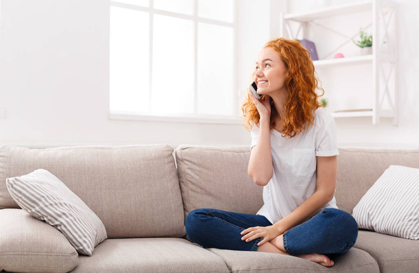 Menina feliz fazendo uma chamada no telefone em casa
 - Foto, Imagem