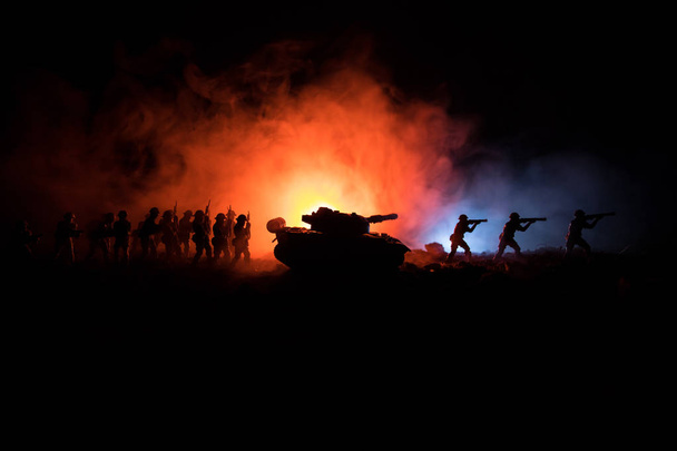 戦争の概念。戦争の霧空のシーンをかけて戦う軍のシルエットの背景、夜曇りスカイライン以下世界大戦兵士のシルエット。攻撃シーン。装甲車両。タンクは戦う. - 写真・画像
