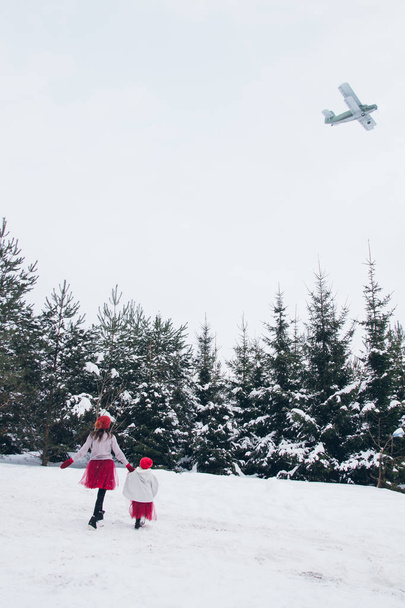 Woman and her daughter have fun in the winter forest  - Photo, image