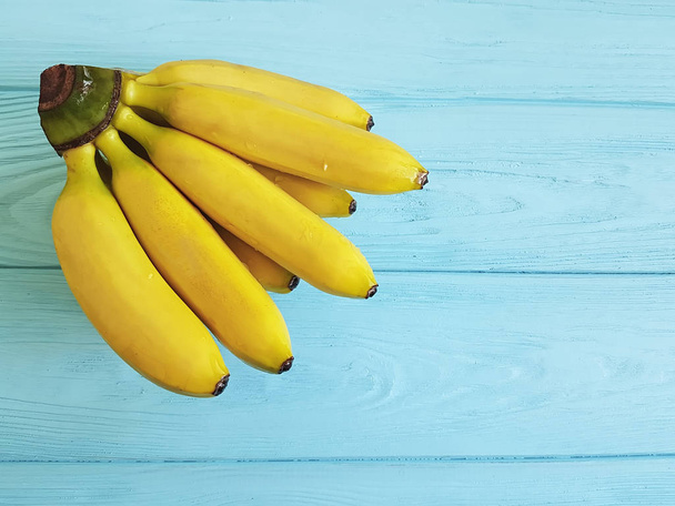 青い木製の背景に熟したバナナ - 写真・画像
