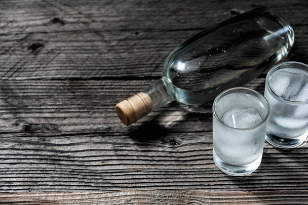 Soğuk votka veya cin ahşap masa ile iki fondip bardakları, - Fotoğraf, Görsel