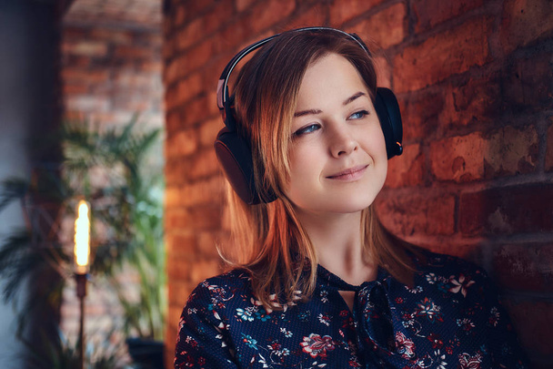 Retrato de una rubia feliz y encantadora con auriculares escuchando música
 - Foto, imagen