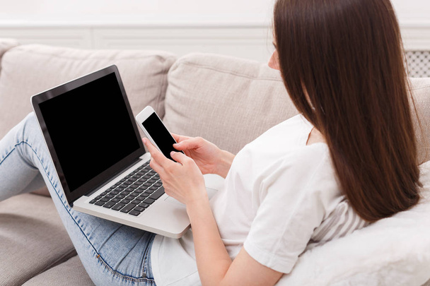 Menina morena irreconhecível com laptop sentado no sofá
 - Foto, Imagem