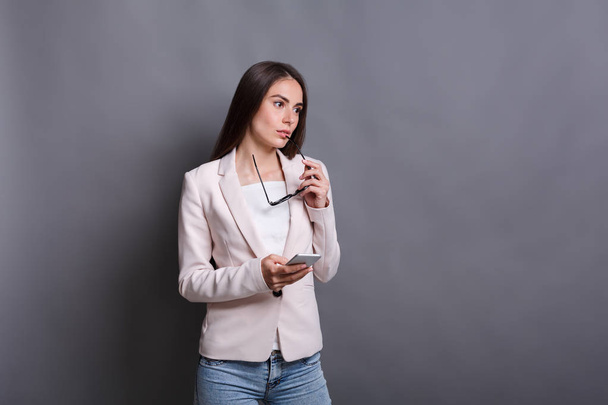 Pensive brunette business lady tekstailu matkapuhelimeen
 - Valokuva, kuva