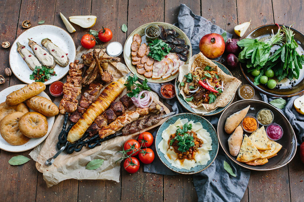 Outdoors Food Concept. Appetizing barbecued steak, sausages and grilled vegetables on a wooden picnic table. - Foto, Imagem