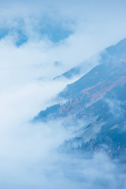 foggy mountain landscape with clouds above the peaks - Fotó, kép