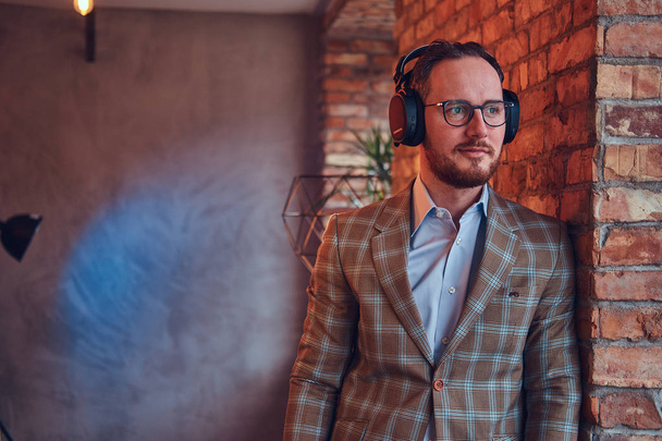 Portrait of a stylish man in a flannel suit and glasses - Photo, Image