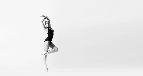 Baleriny taktowny taniec w wykonaniu sztuki. Młoda i piękna baletnica w czerni i bieli. - Zdjęcie, obraz