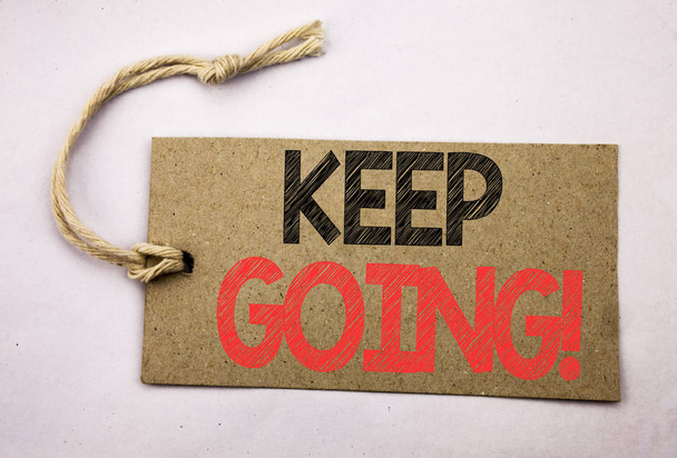 Hand writing text caption inspiration showing Keep Going. Business concept for Go Moving Forward Letting written on price tag paper on the white vintage background. - Photo, image