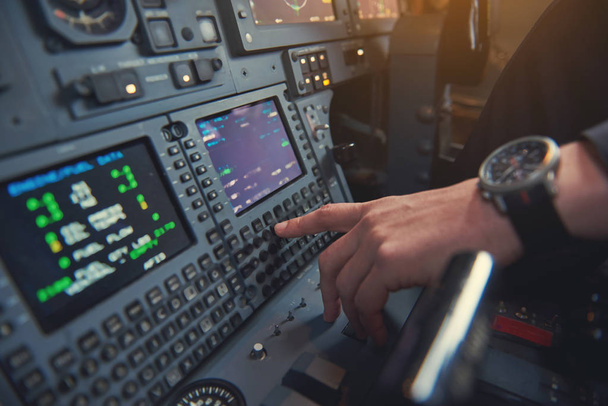 Pilot hand pressing knob in cabin - Фото, зображення