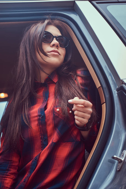 Portret kaukaski kobieta koszula flanelowa, siedząc w samochodzie. - Zdjęcie, obraz