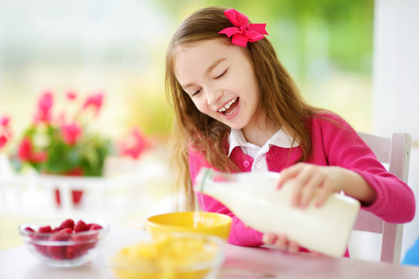 mała dziewczynka jeść płatki kukurydziane - Zdjęcie, obraz