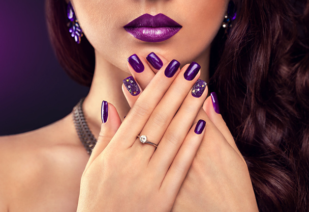 Belle femme avec un maquillage parfait et une manucure violette portant des bijoux
 - Photo, image