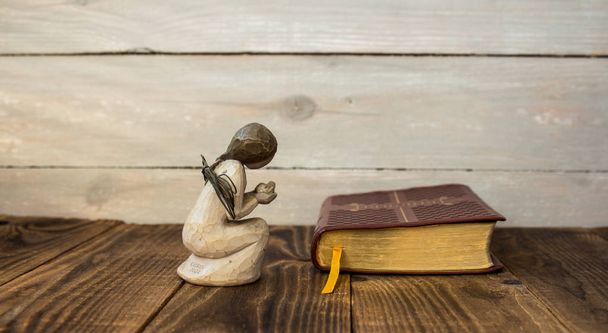 Angel és a Biblia, a fából készült háttér - Fotó, kép