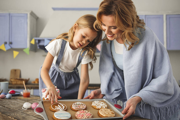 Cheerful mom and kid cooking in the cuisine - Fotoğraf, Görsel