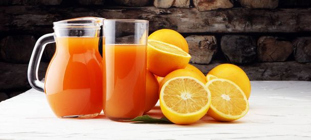 γυάλινο βάζο φρέσκο χυμό πορτοκαλιού με φρέσκα φρούτα σε λευκό πίνακα - Φωτογραφία, εικόνα