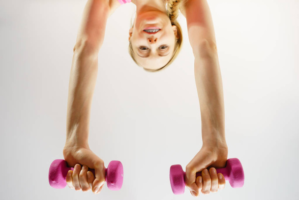 Teenage woman working out at home with dumbbell - Fotó, kép
