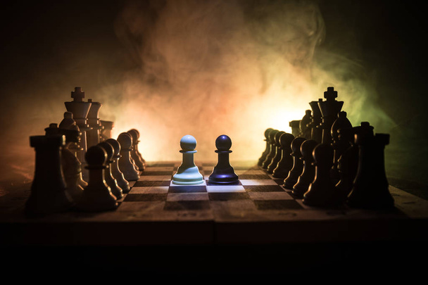 Šachy desková hra koncept podnikatelských nápadů a precizní strategie a soutěž myšlenek. Šachové figury na tmavém pozadí se kouře a mlhy. Obchodní vedení a důvěru koncept. - Fotografie, Obrázek