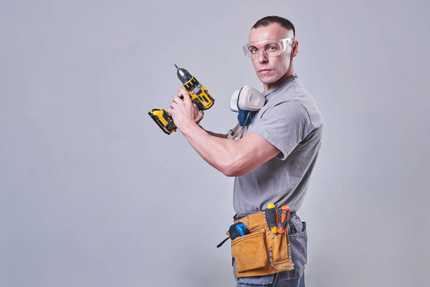 Master Builder-finalizador em roupas de trabalho, com uma chave de fenda na mão
 - Foto, Imagem