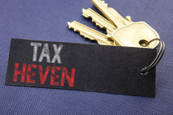 Handwritten text showing Tax Heven. Business concept writing for Profit Taxation  Written on note paper attached to the key, black background with space close up - Photo, Image