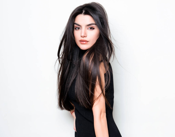 beautiful young woman with long black hair wearing dress and posing on white background - Φωτογραφία, εικόνα