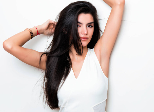 beautiful young woman with long black hair wearing dress and posing on white background - Fotoğraf, Görsel