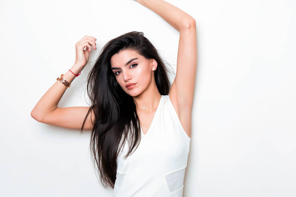 beautiful young woman with long black hair wearing dress and posing on white background - Foto, Imagen