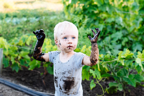 ребенок играет в грязи на улице
 - Фото, изображение