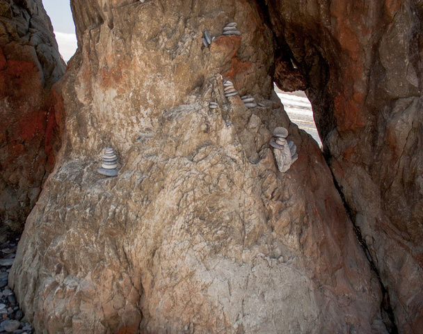 Kleine platte stenen gestapeld in een rotsformatie - Foto, afbeelding