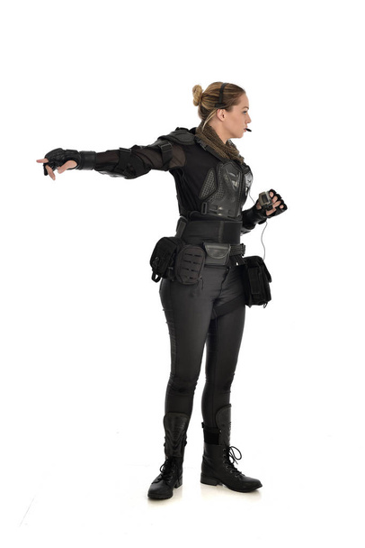 ritratto a figura intera di soldato donna che indossa un'armatura tattica nera con binocolo isolato su sfondo bianco
. - Foto, immagini
