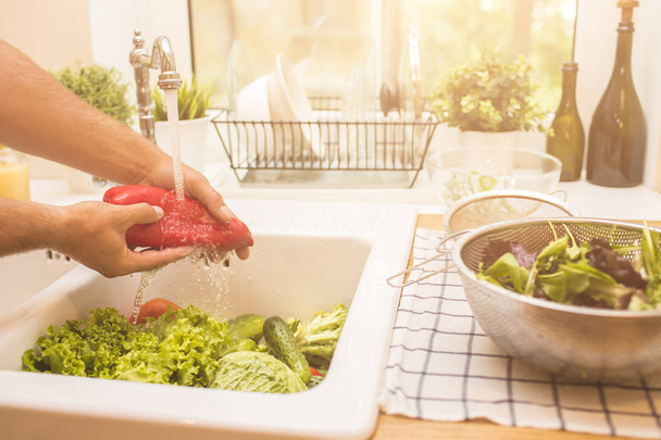 Man washing vegetables before eating - Фото, изображение
