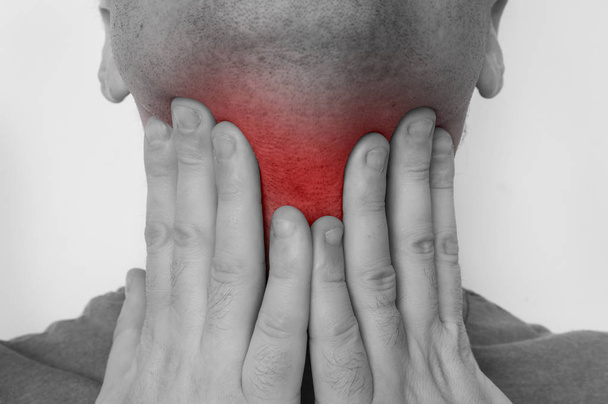 Man met zere keel houdt zijn pijnlijke keel - Foto, afbeelding